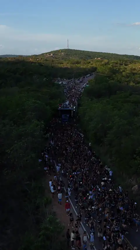 Vista aérea da multidão numa curva da estrada, com as serras ao fundo